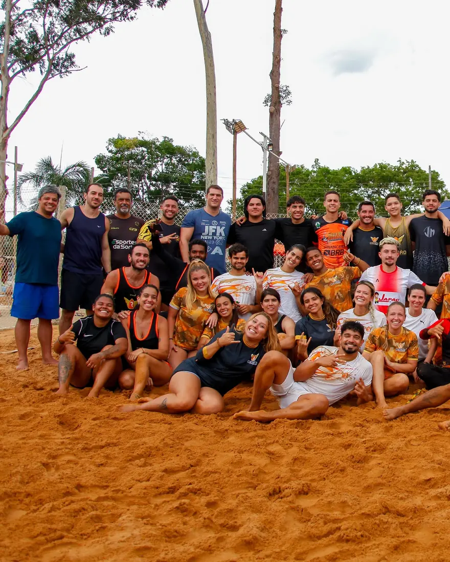 Grupo de alunos do Reação Sports reunido na areia depois de um campeonato interno